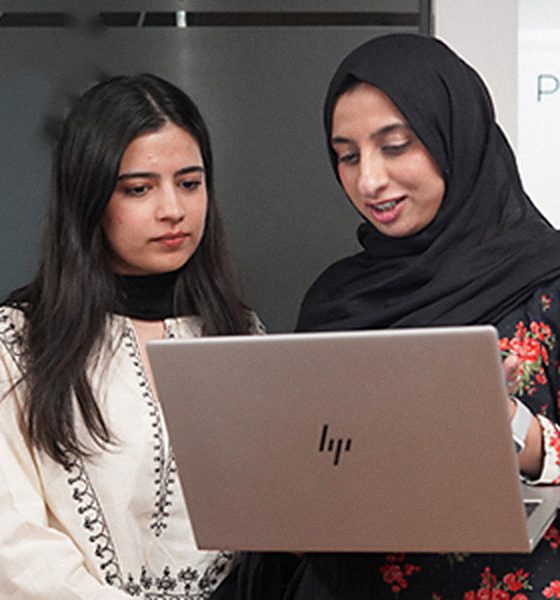 Two HexaClicks colleagues reviewing work on a laptop together.