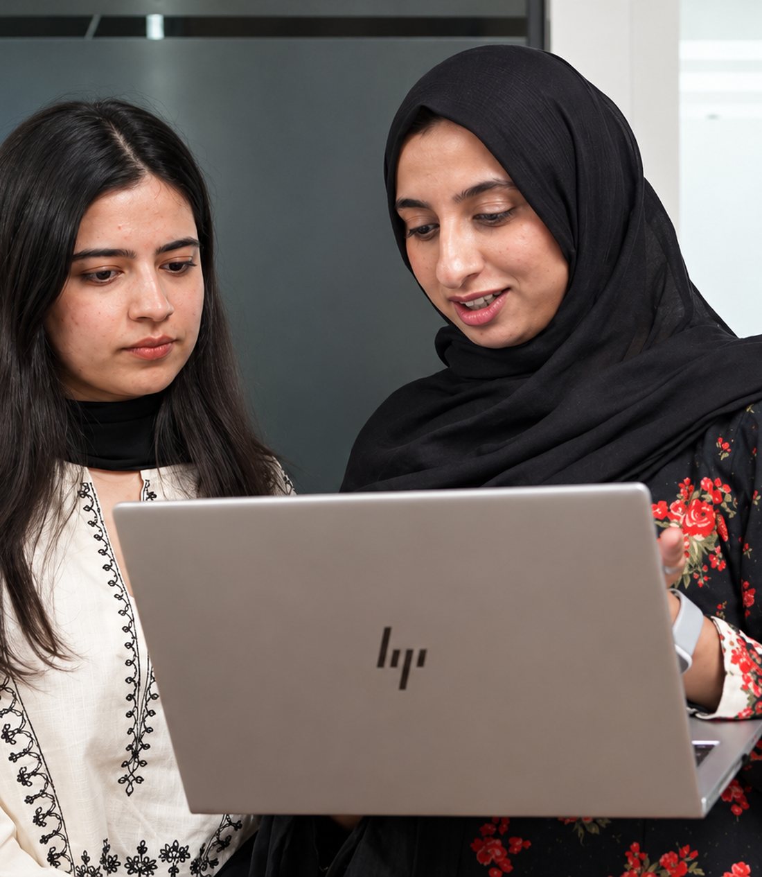 Two HexaClicks colleagues reviewing work on a laptop together.