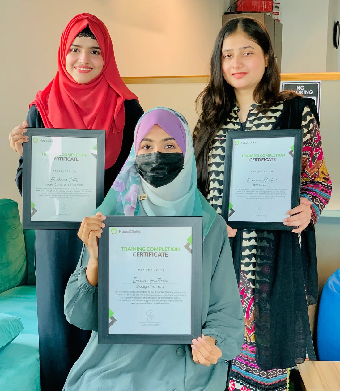 Three HexaClicks trainees holding their training completion certificates.